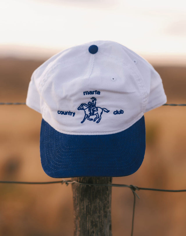 White and Liberty-blue Marfa Country Club Rider’s Cap on a fence post
