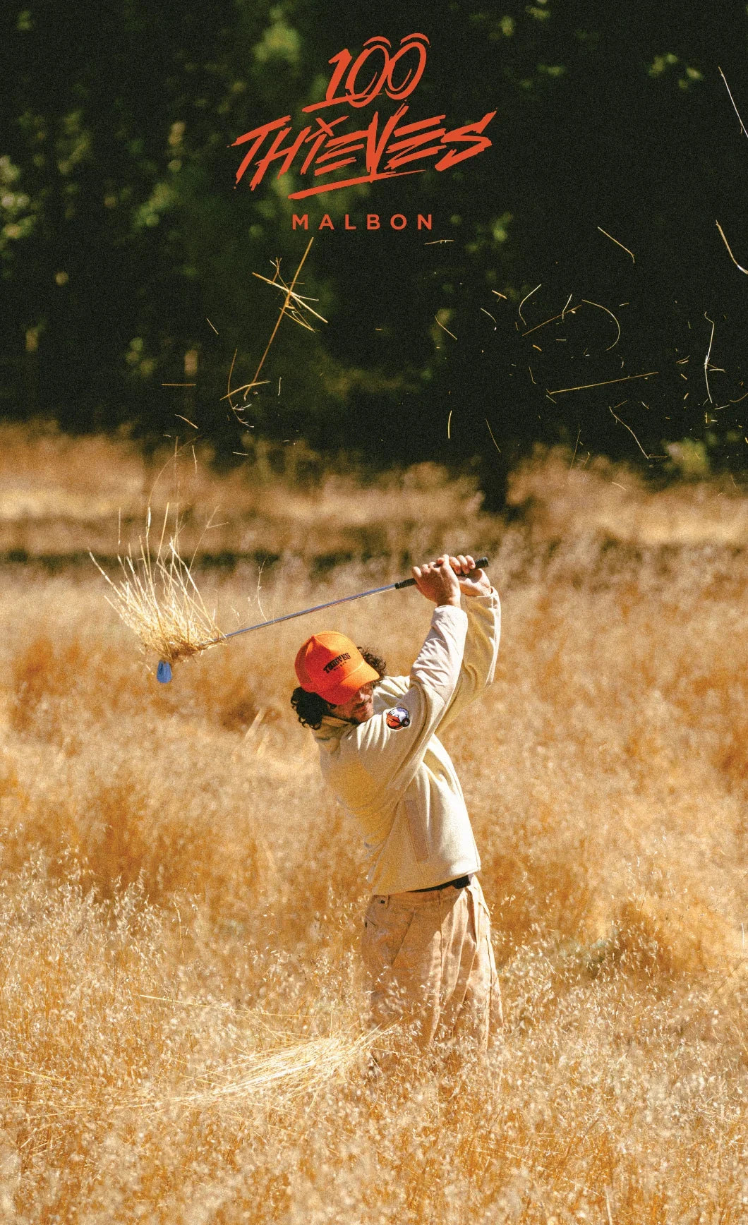 golfer swinging in dry grass field
