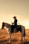 Cowboy wearing the black Marfa Country Club Club Issue crewneck on horseback