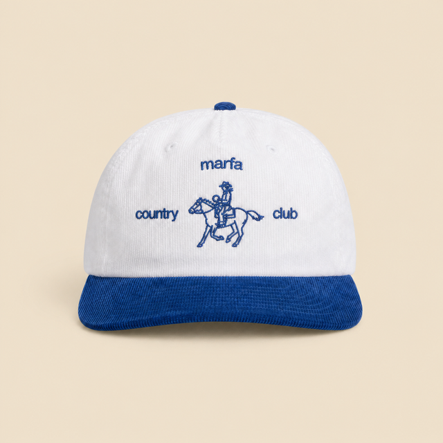 White and Liberty-blue Marfa Country Club Rider’s Cap on a clean warm beige background